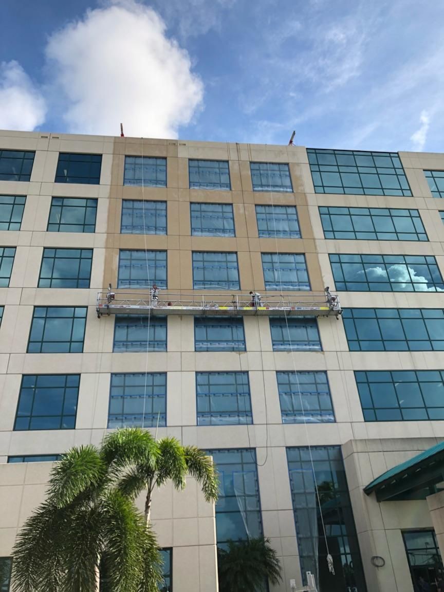 A large building with a lot of windows is being painted