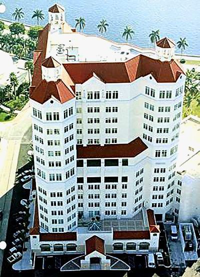 An aerial view of a large white building with red roofs