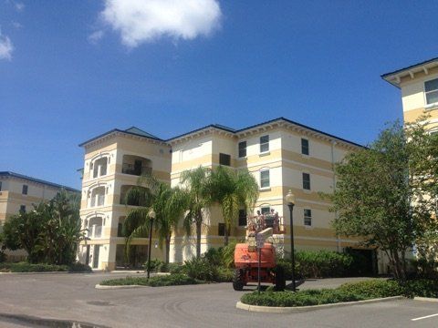 A large apartment building with palm trees in front of it