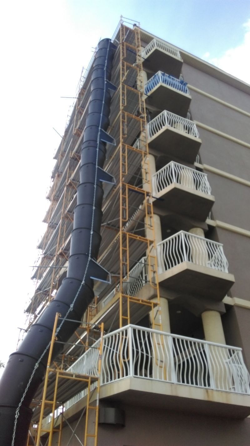 A building under construction with scaffolding and balconies.