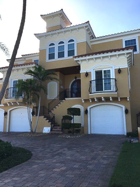 A large house with white garage doors and stairs