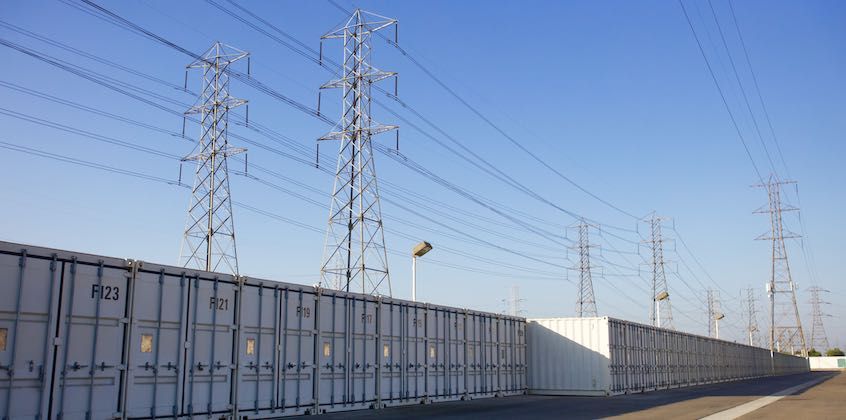 Row of shipping container storage units beneath power lines