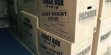 Stacked large moving boxes labeled light weight stuff