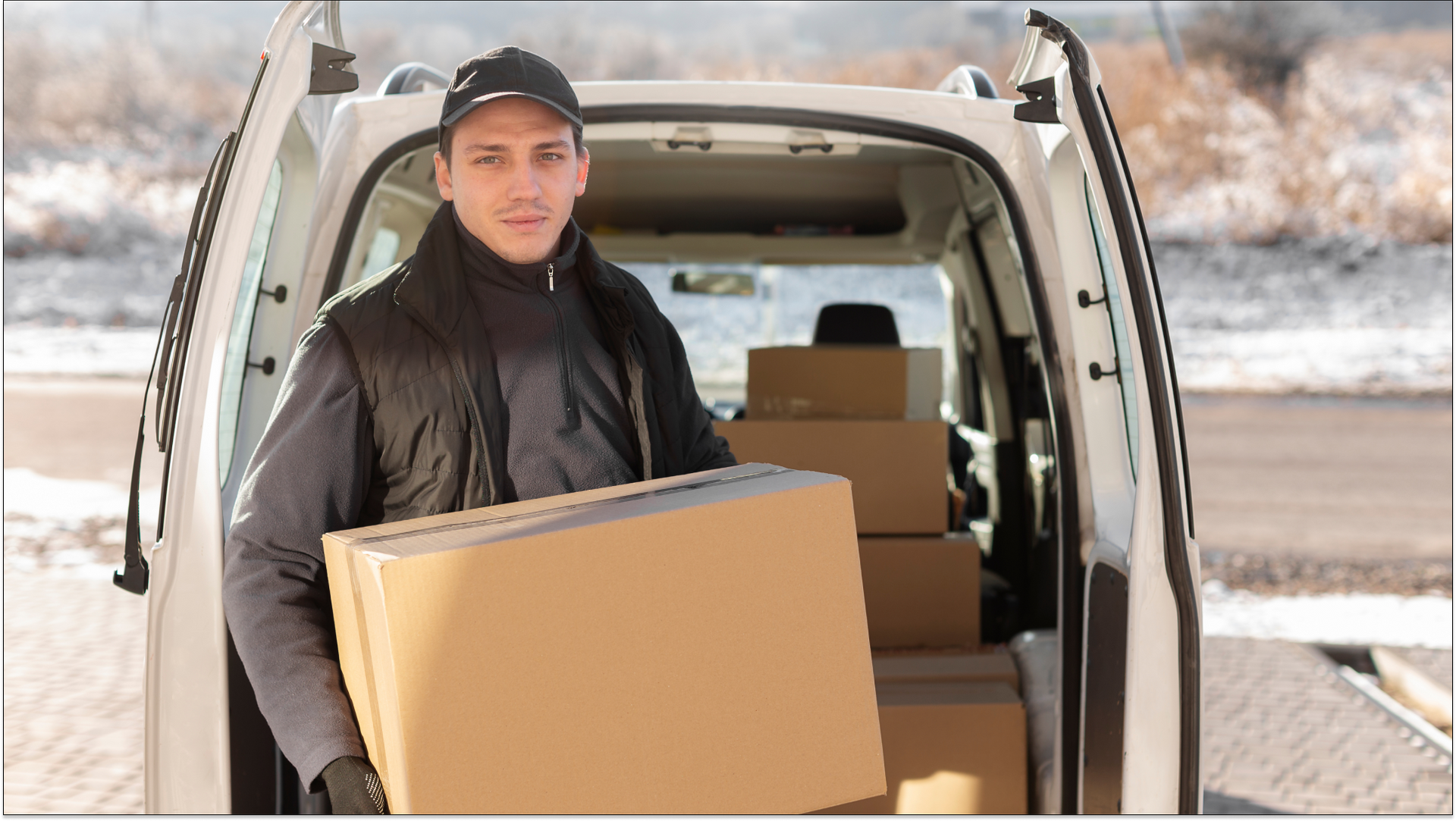 man standing outside of his car holding storage boxes