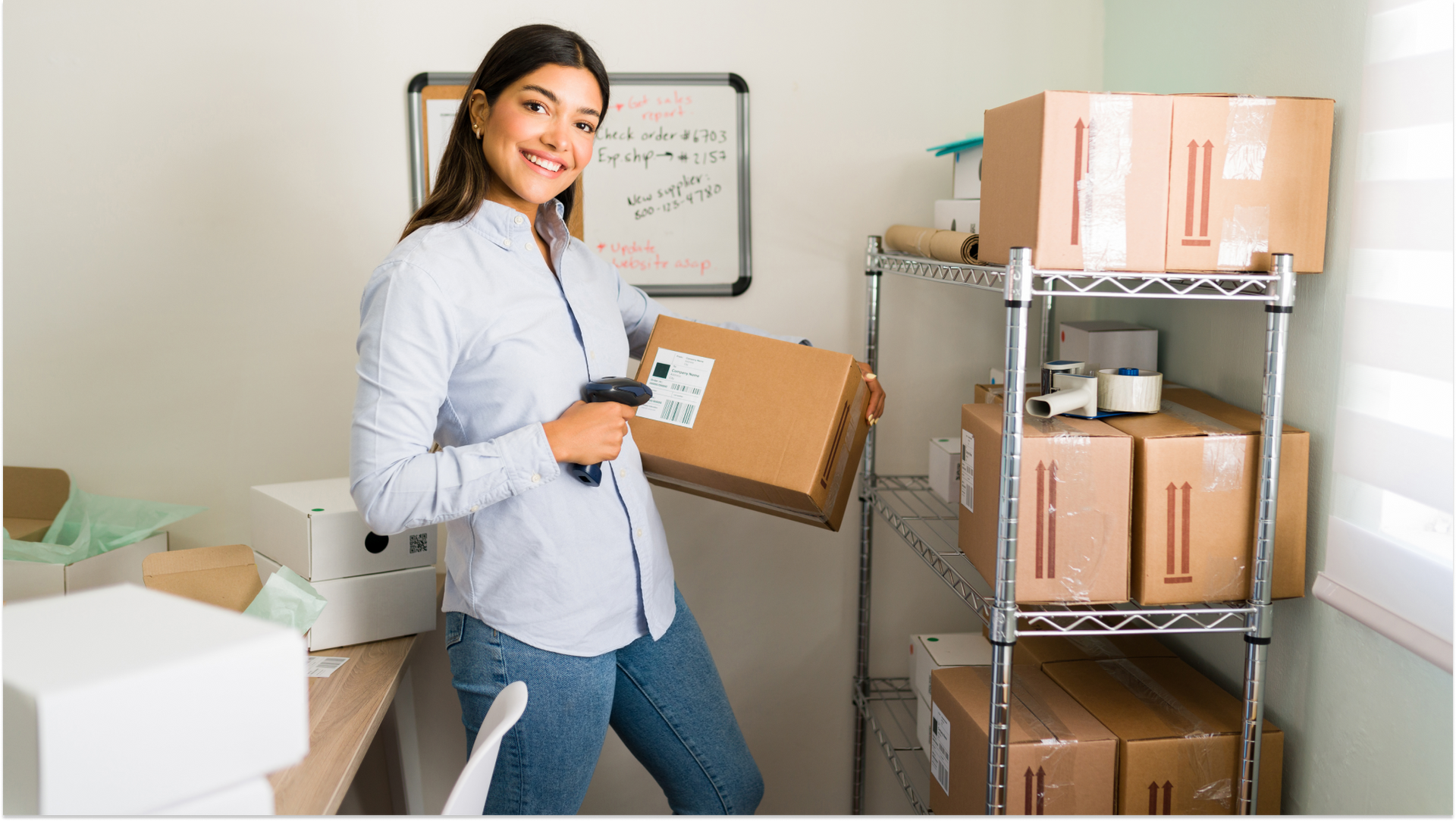 woman standing in office scanning storage boxes
