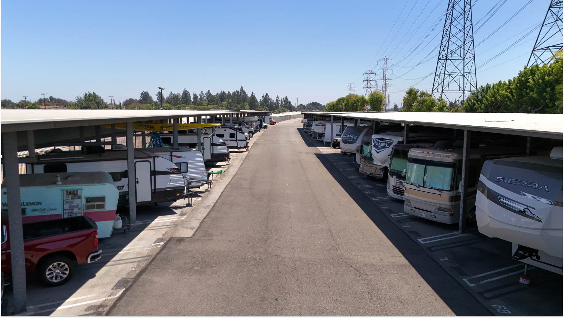 outdoor canopy covering rv's and trucks with a wide aisle between them