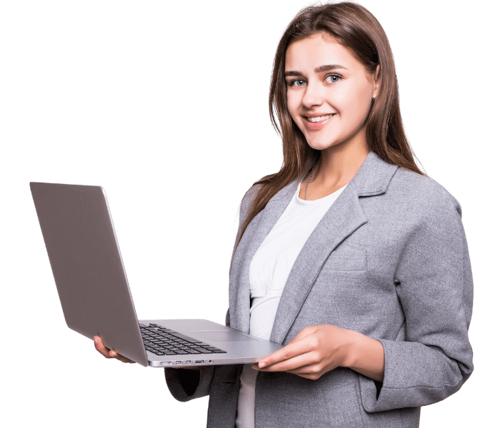 Woman in gray blazer smiling, holding a laptop.