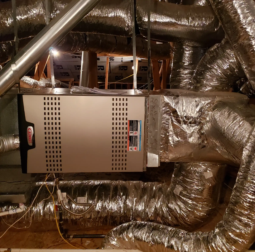 HVAC furnace and shiny insulated ductwork in an attic