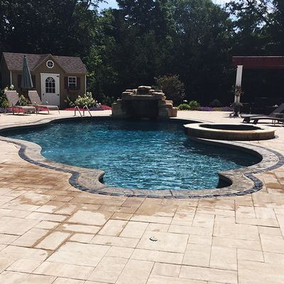 A large swimming pool with a house in the background