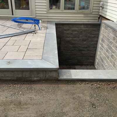 A brick wall with a hole in it next to a patio.