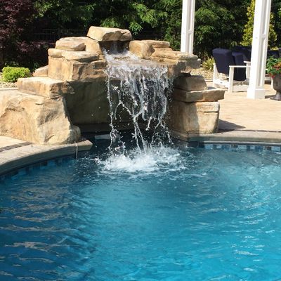 A waterfall is in the middle of a swimming pool