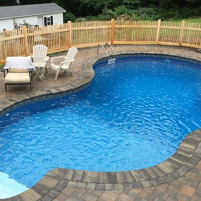 A large swimming pool with a wooden fence around it