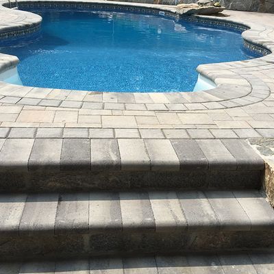 A large swimming pool with stairs leading to it.