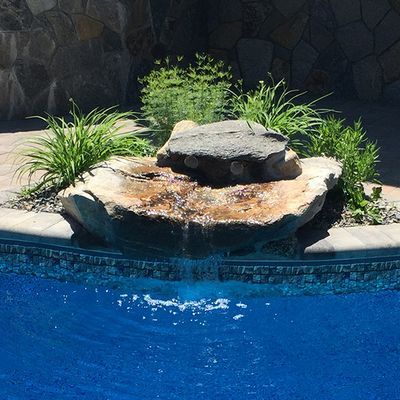 A pool with a waterfall in the middle of it