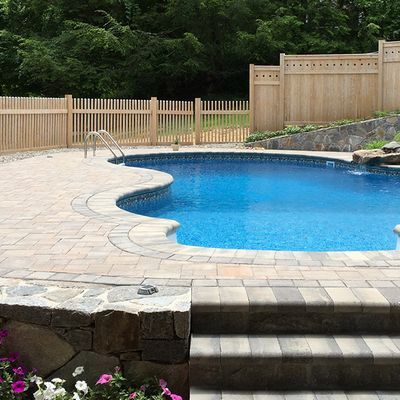 A large swimming pool with a wooden fence around it