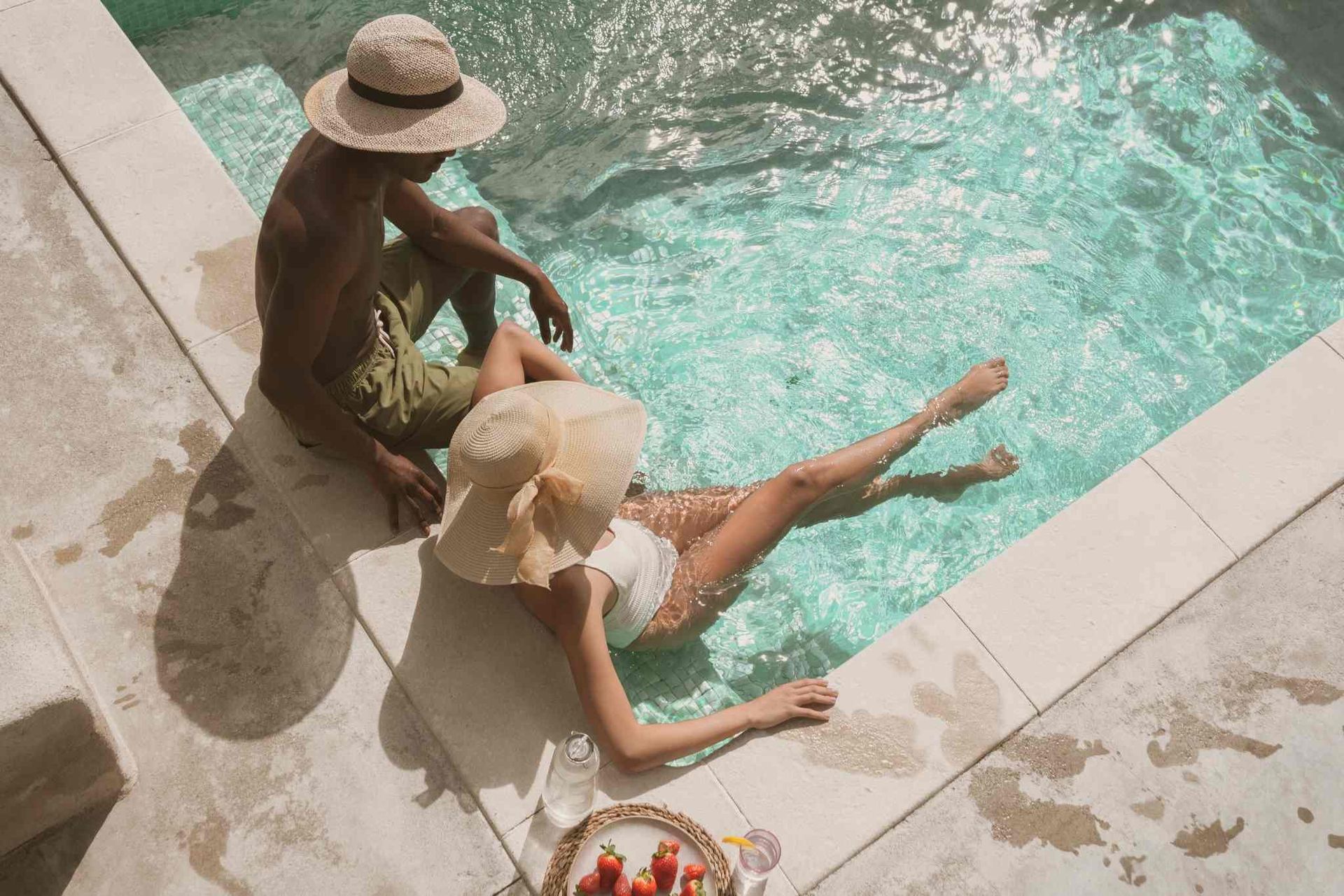couple with a summer hat soaking in pool