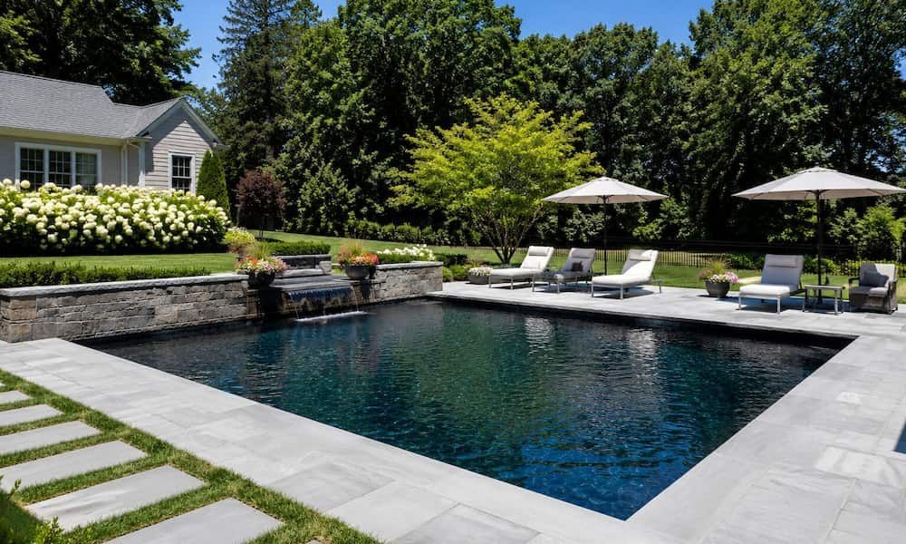 Modern backyard pool with dark interior finish