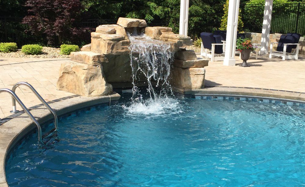 There is a waterfall in the middle of the pool.