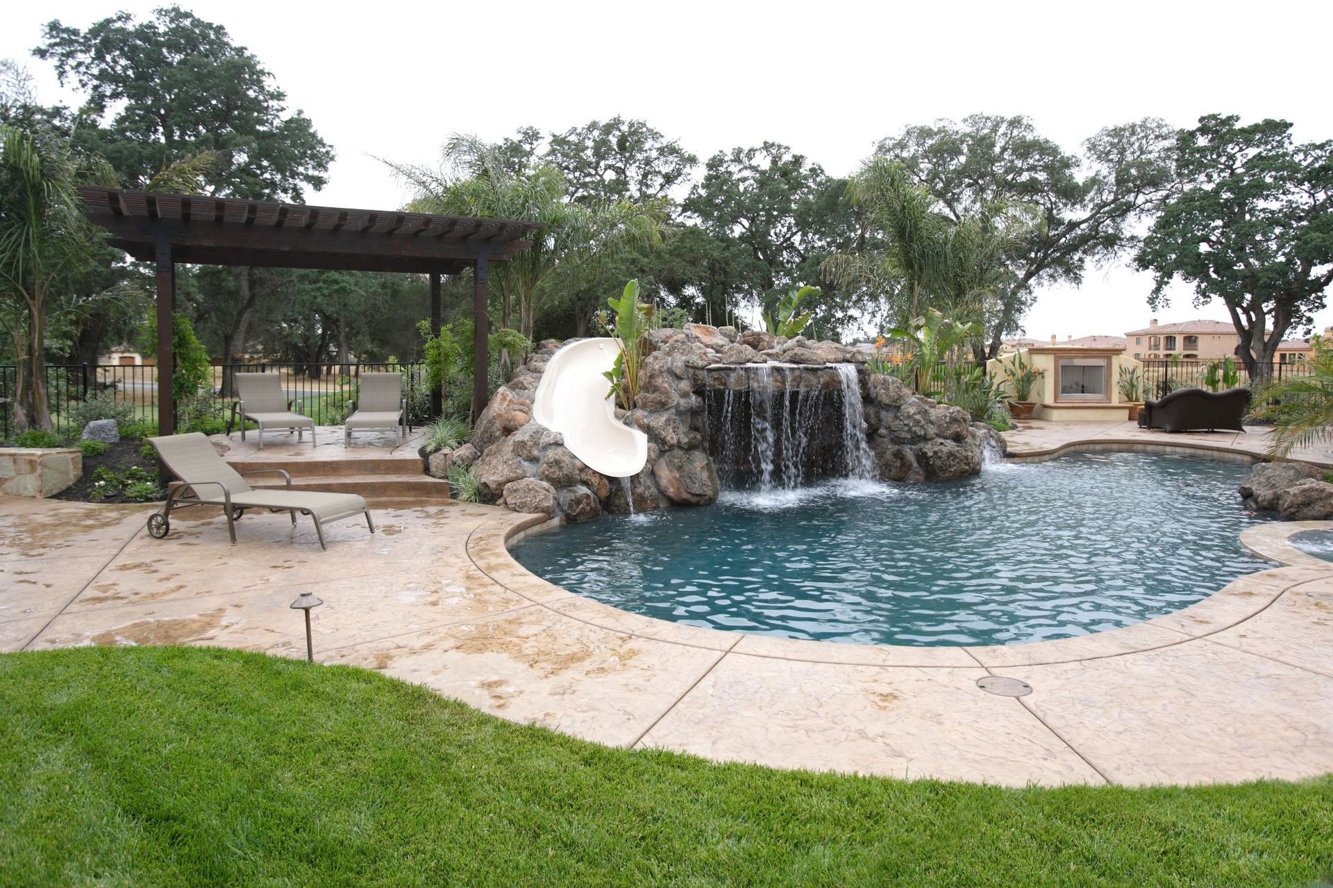 A swimming pool with waterfall and a slide