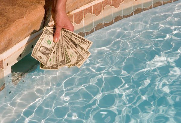 Hand holding cash over pool