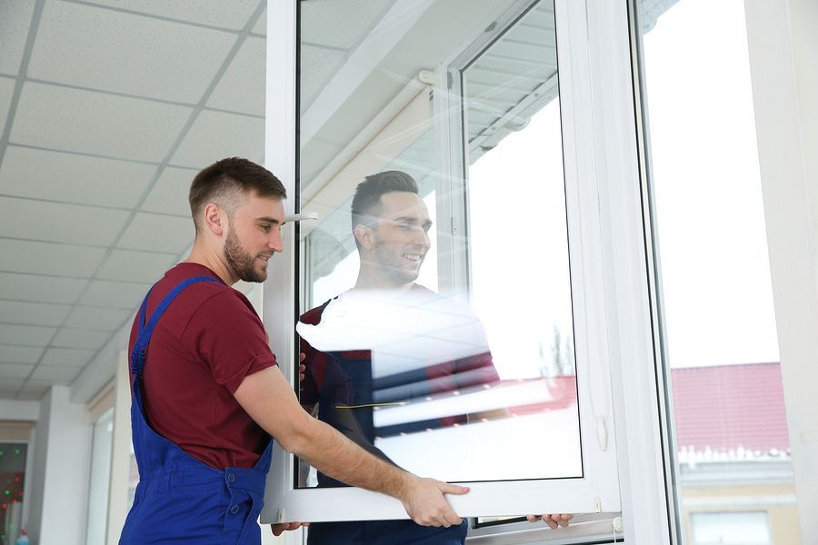 a man in overalls and a red shirt is opening a sliding glass door