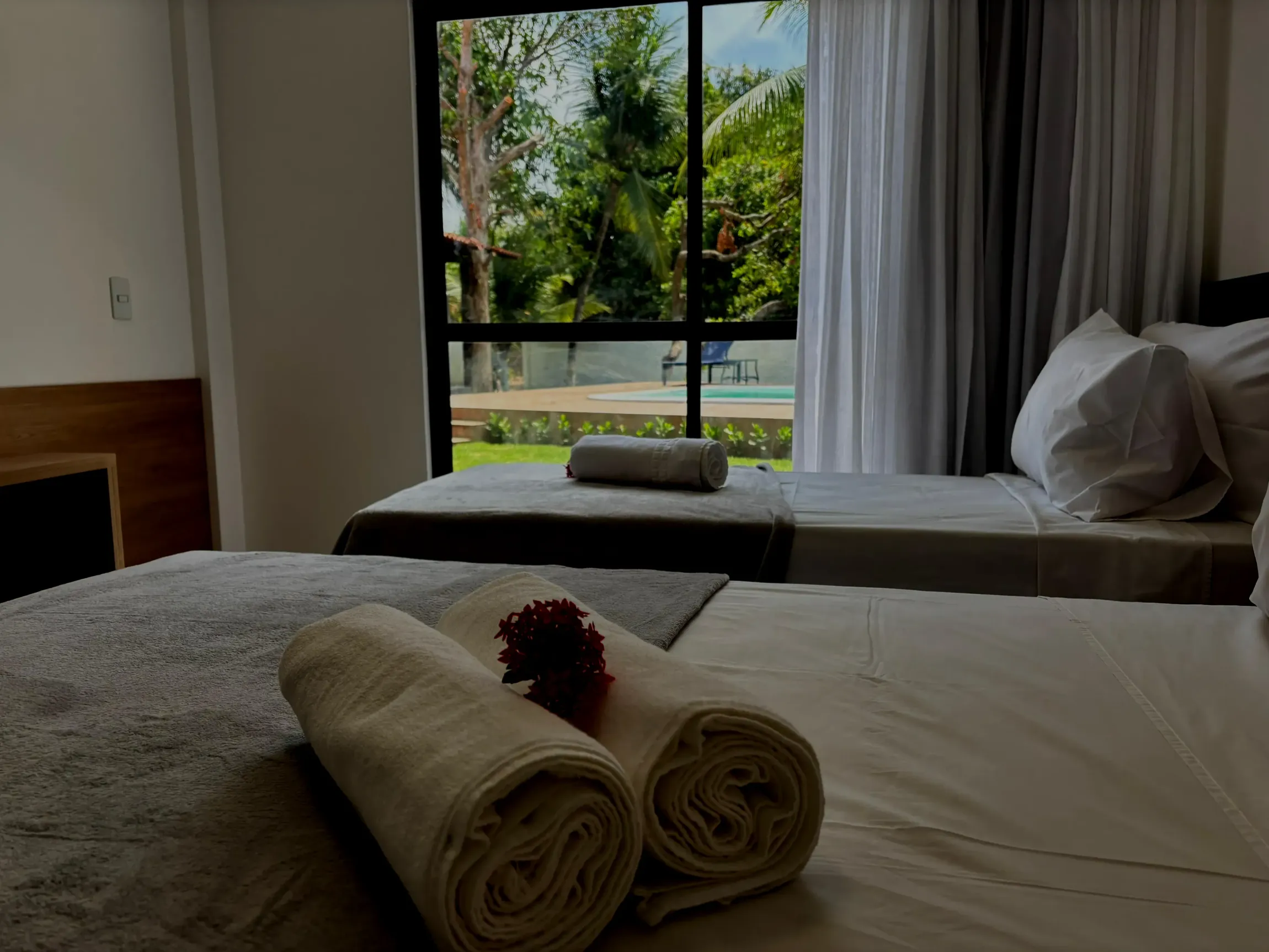Um quarto de hotel com duas camas e duas toalhas na cama. Coralli Pousada