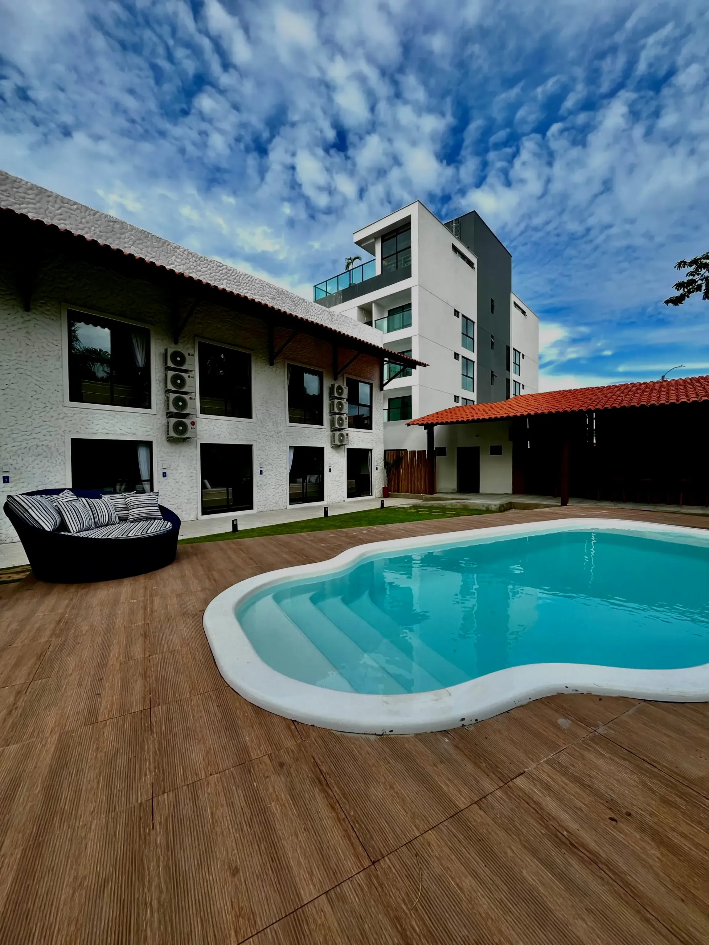 Um grande edifício com uma piscina na frente. Coralli Pousada