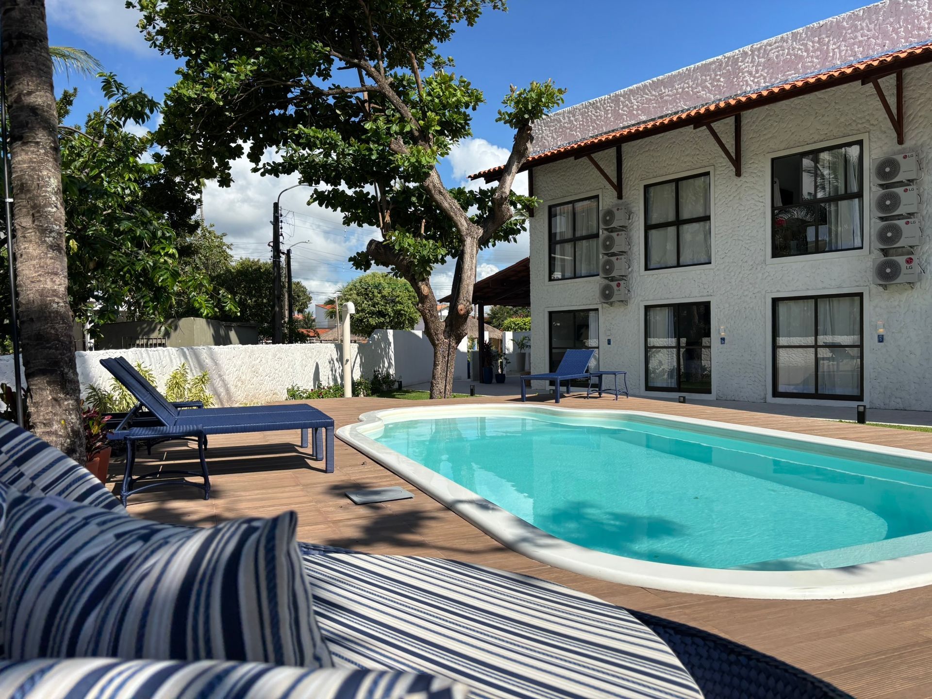 Um grande edifício branco com uma piscina na frente. Coralli Pousada