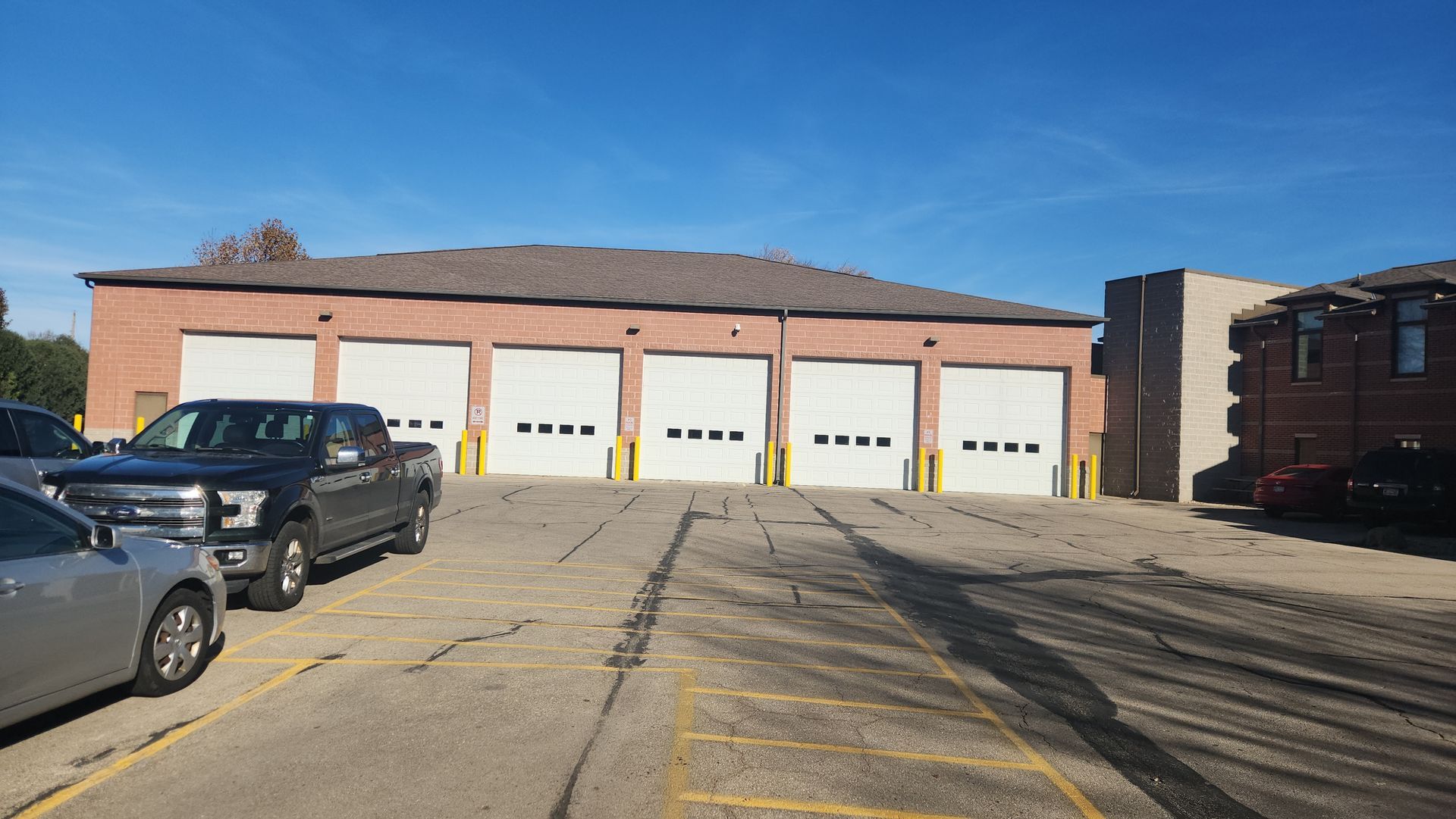 A parking lot with cars parked in front of a building.