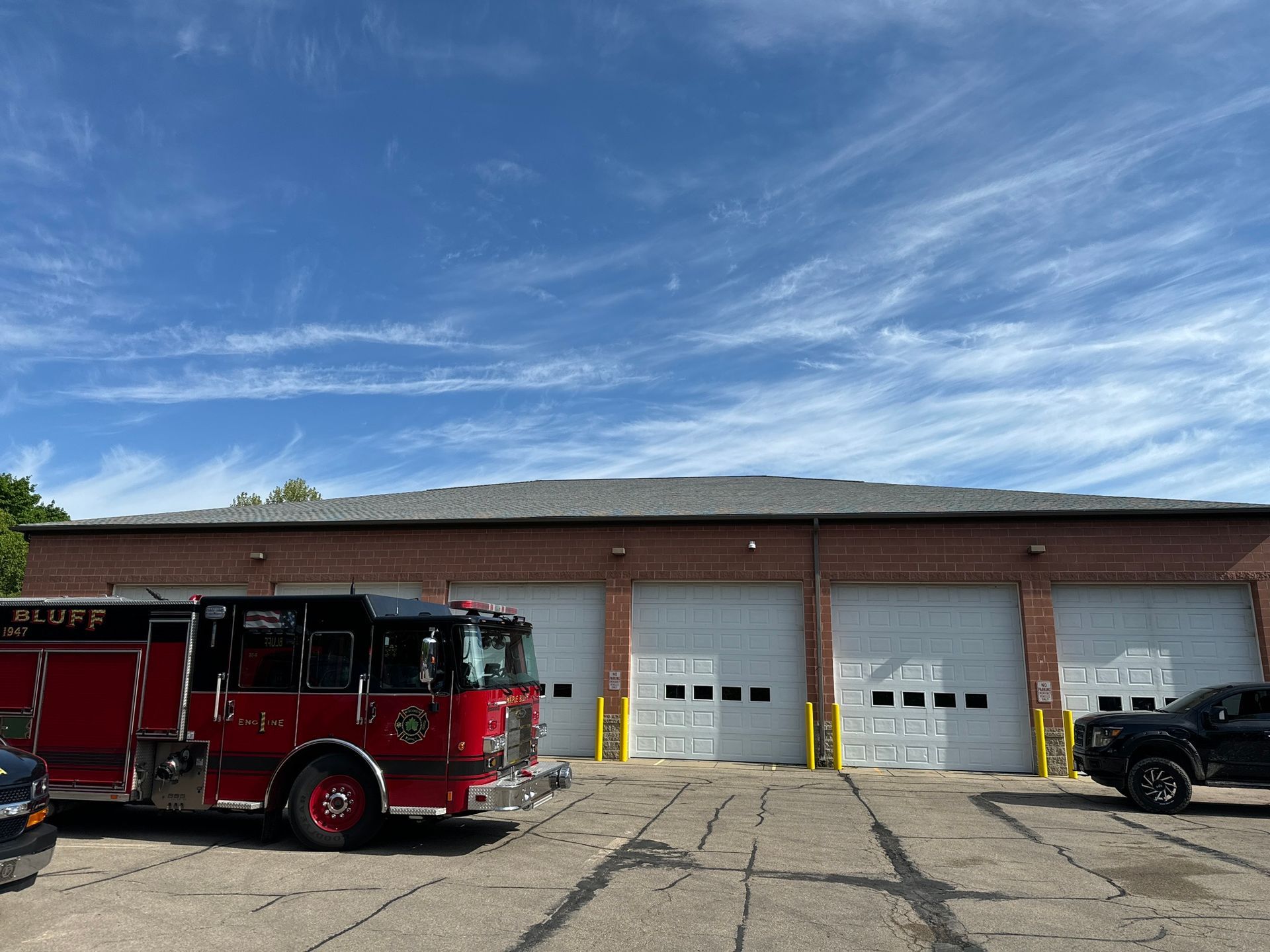 A red fire truck is parked in front of a brick building.