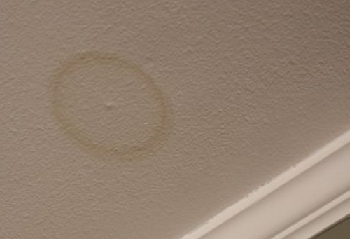 There is a water stain on the ceiling that looks like a circle.