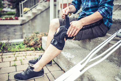 Man adjusting his orthosis — Fayetteville, NC — Total Rehab Orthotics & Prosthetics