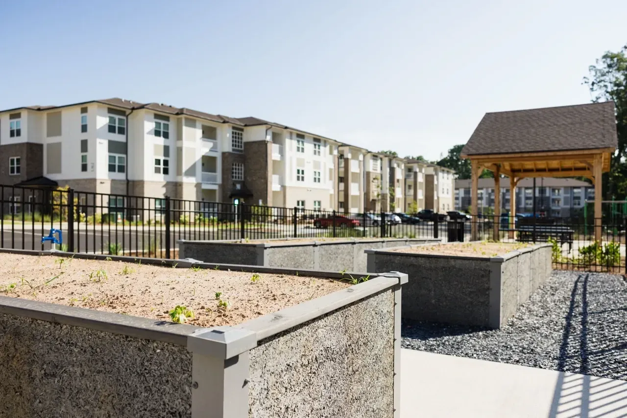 Exterior view of an apartment community courtyard with planters and a gazebo.