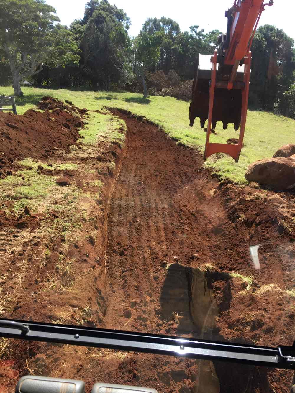 An Excavator is Digging a Hole in the Dirt in a Field — Eggins Earth & Road in Ballina, NSW