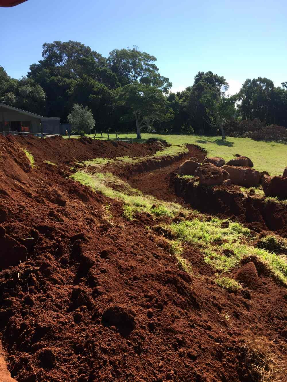 A Large Pile of Dirt in a Field With Trees in the Background — Eggins Earth & Road in Byron Bay, NSW