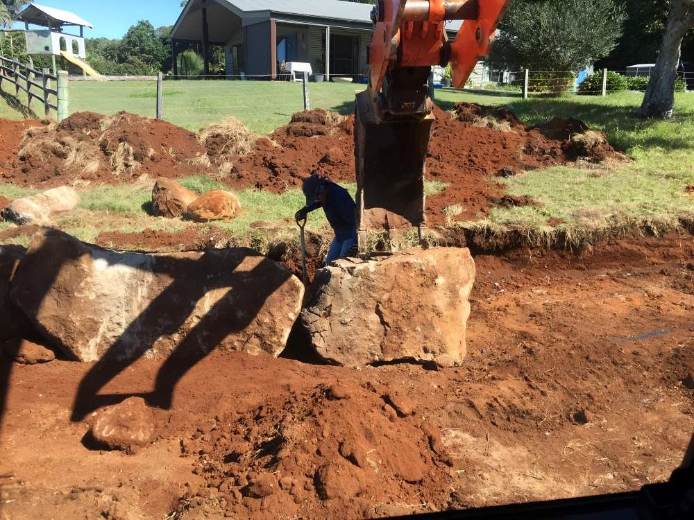 A Man is Digging in the Dirt in Front of a House — Eggins Earth & Road in Wardell, NSW