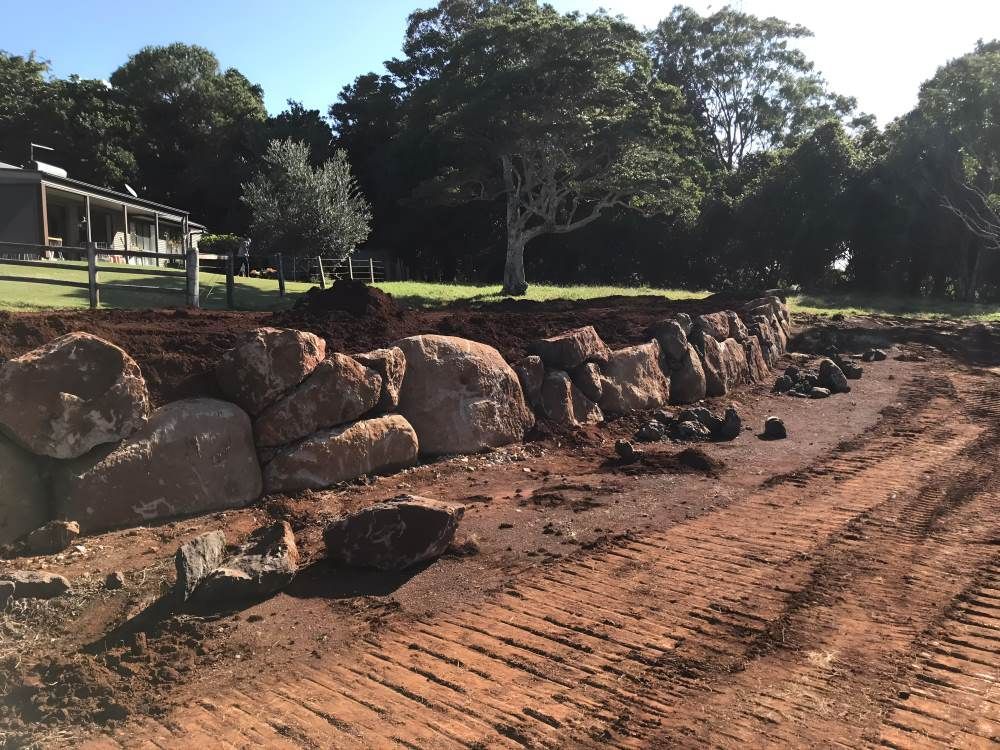 A Large Rock Wall is Being Built in Front of a House — Eggins Earth & Road in Wardell, NSW