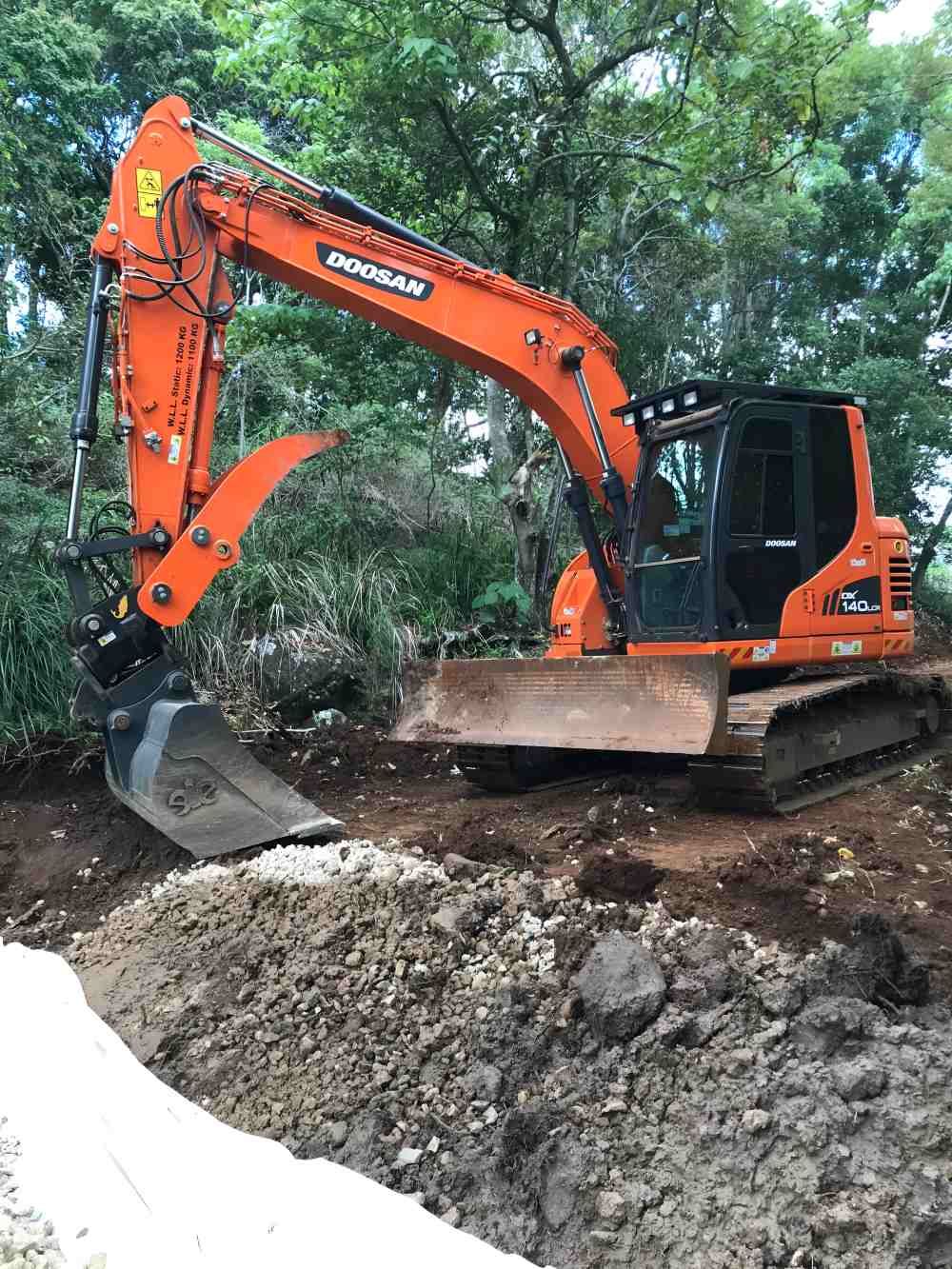 A Large Orange Excavator is Digging a Hole in the Dirt — Eggins Earth & Road in Lismore, NSW