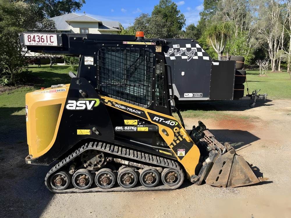 A Bulldozer is Parked in a Driveway Next to a Trailer — Eggins Earth & Road in Wardell, NSW