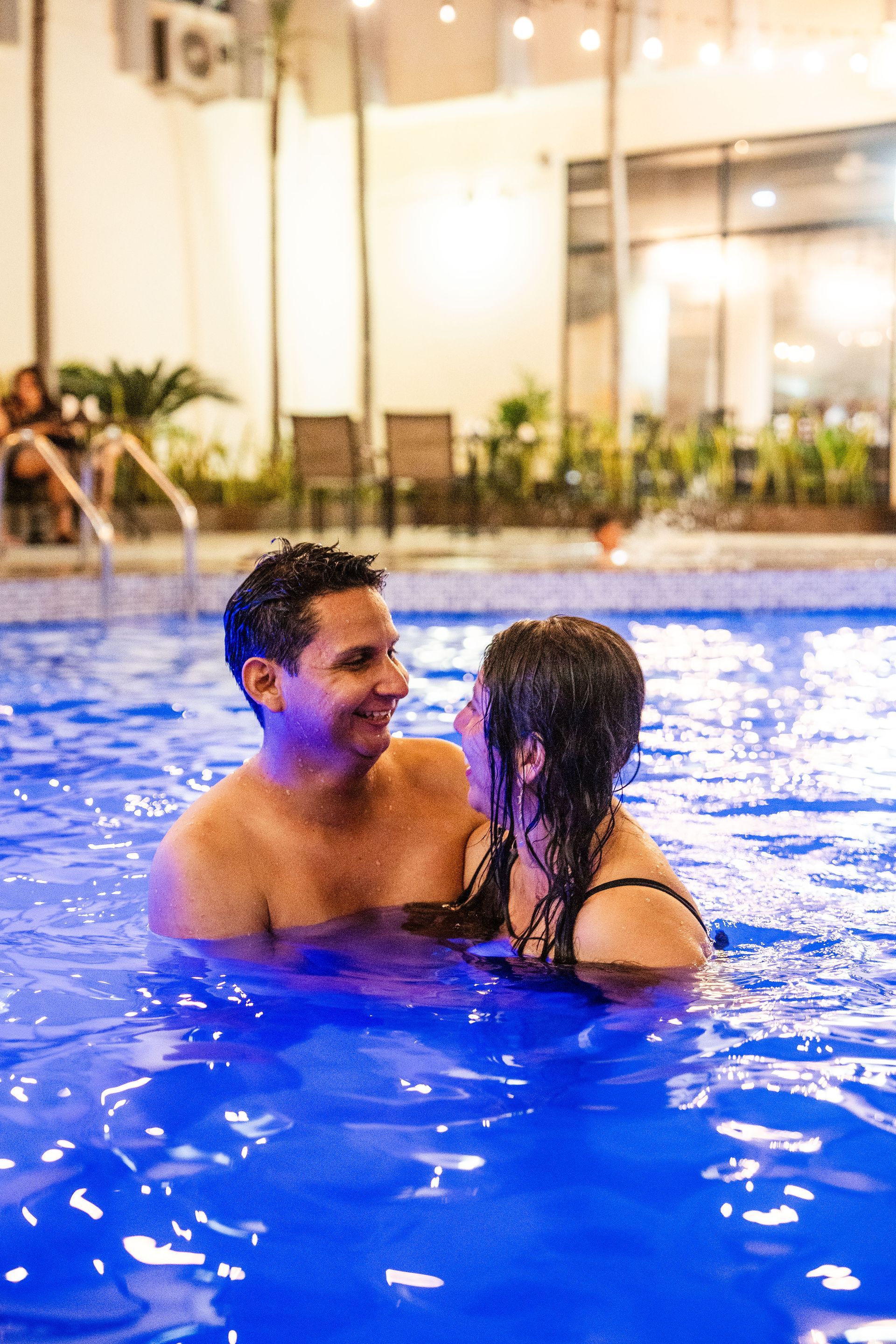 Un hombre y una mujer se miran en una piscina.
