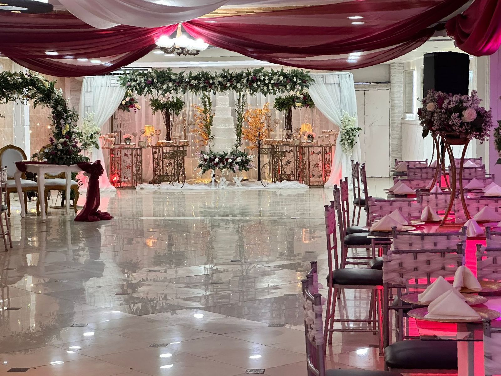 Una gran sala decorada para una recepción de boda con mesas y sillas.