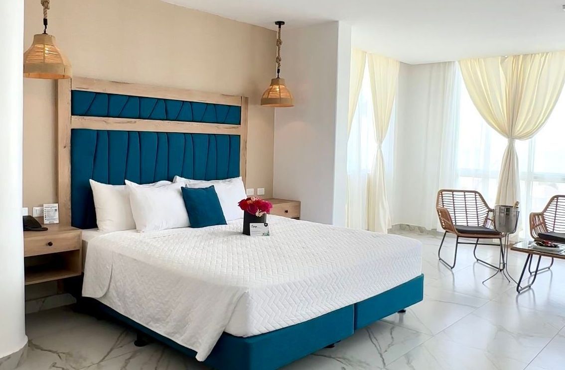 Una habitación de hotel con una cama tamaño king y dos sillas.