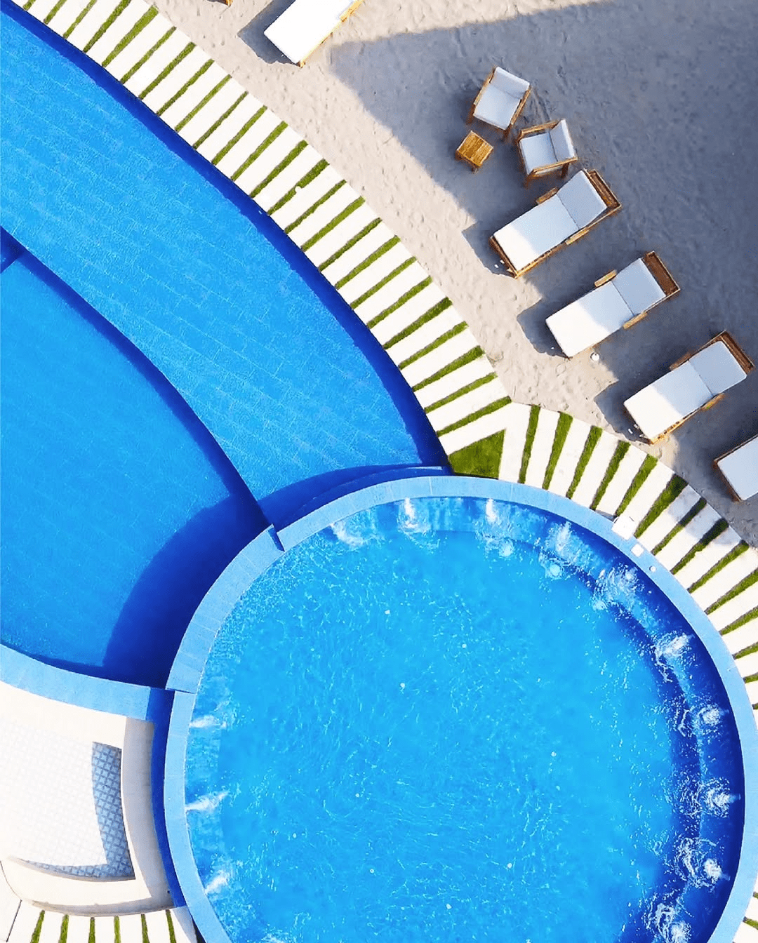 Una vista aérea de una piscina con sillas alrededor.