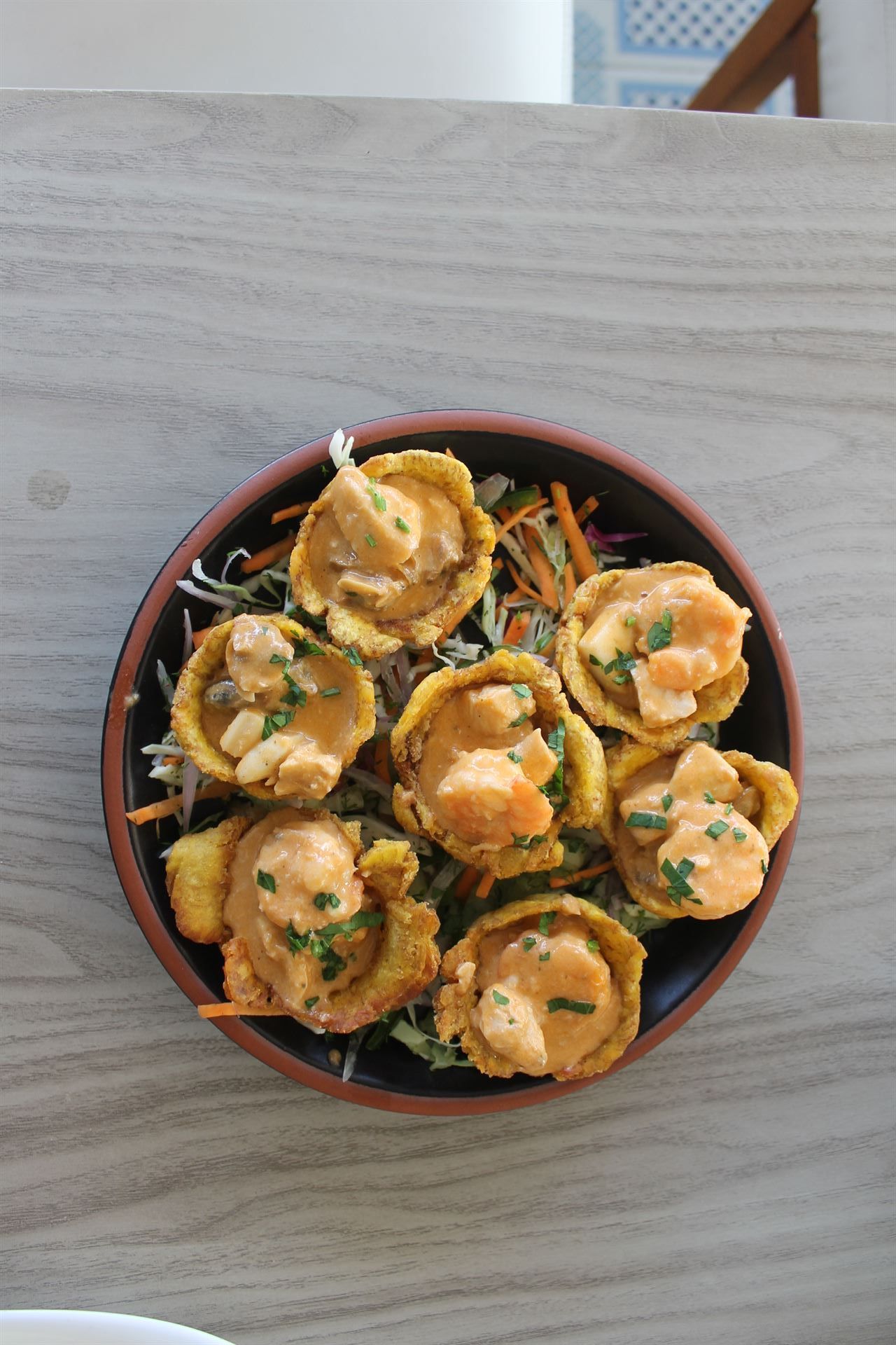 Un plato de comida con camarones y verduras en una mesa.