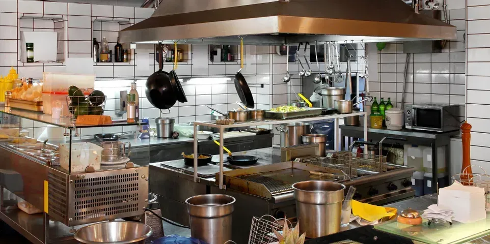 A kitchen with a lot of pots and pans on the counter.