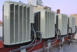 A row of air conditioners sitting on top of a building. A row of air conditioners sitting on top of a building.
