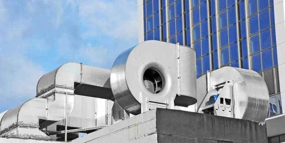 A building with a lot of pipes and fans on top of it.