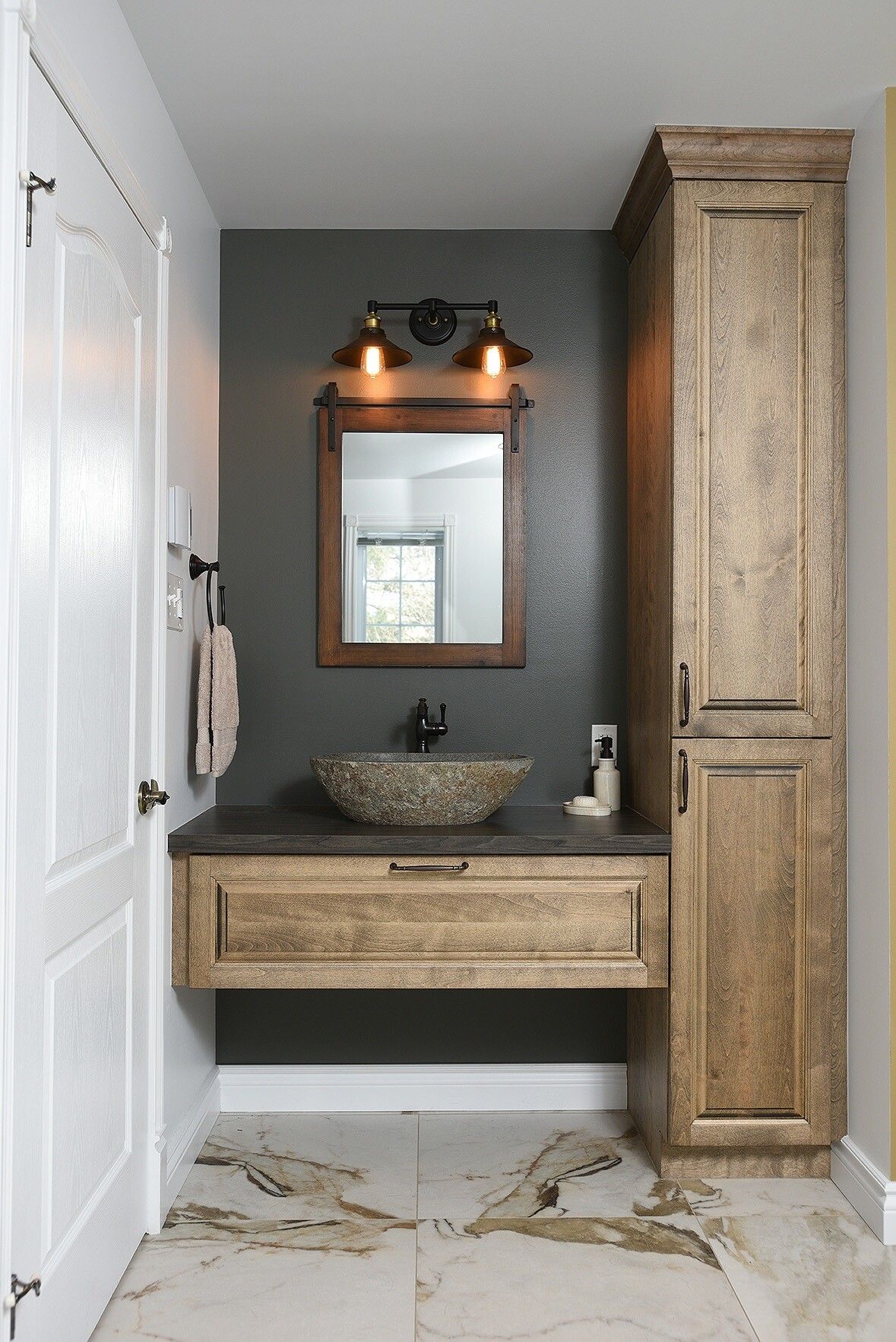 Une salle de bain avec un lavabo, un miroir et des armoires.