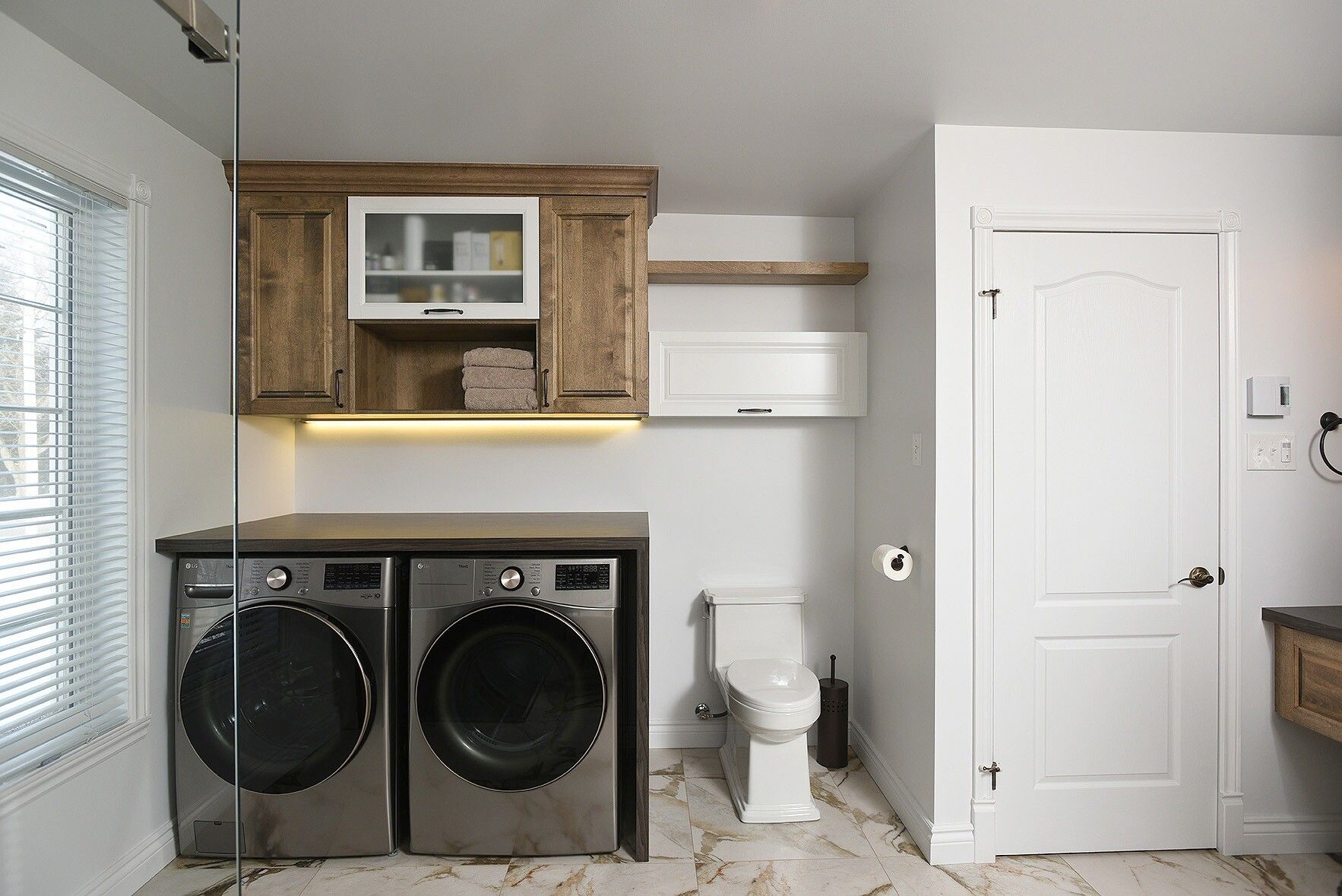 Une buanderie avec lave-linge et sèche-linge et un WC.