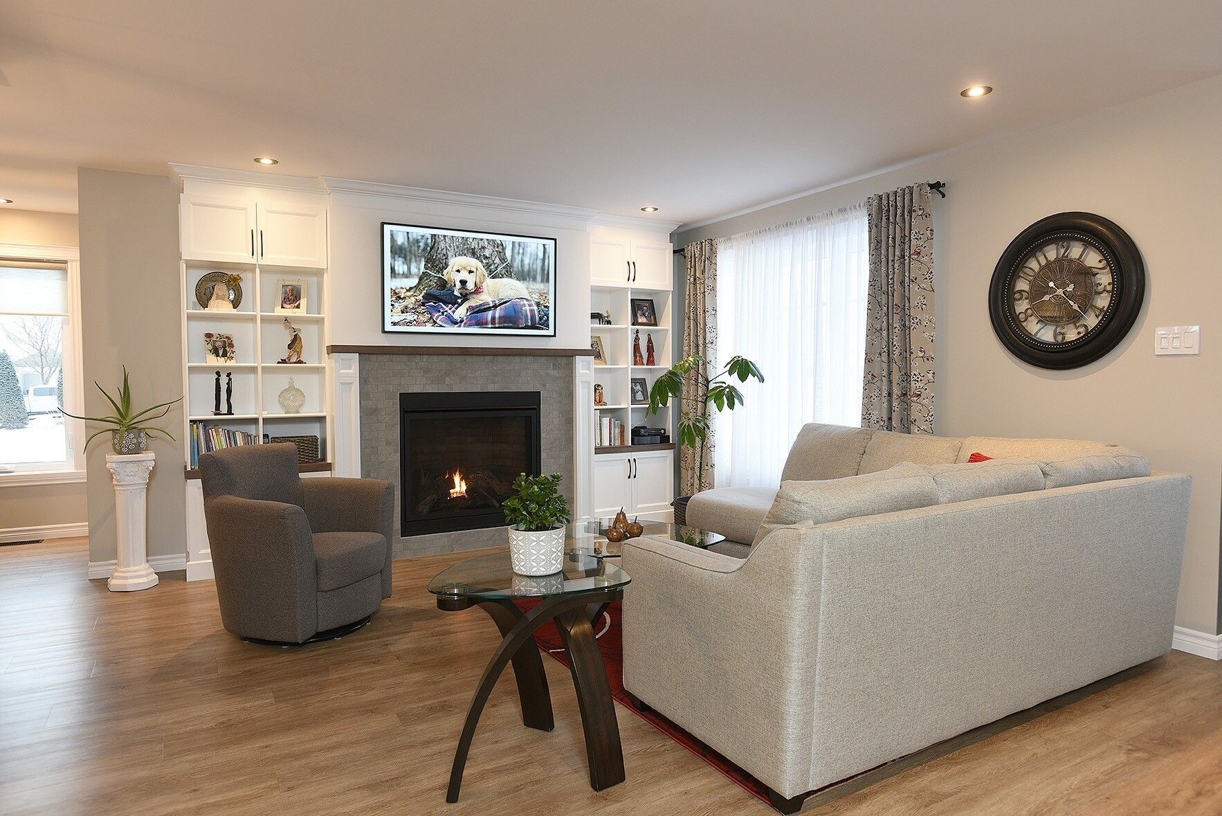 Un salon avec un canapé, des chaises, une cheminée et une télévision.